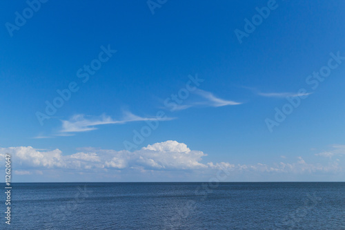 blue sea, blue sky, white cirrus clouds