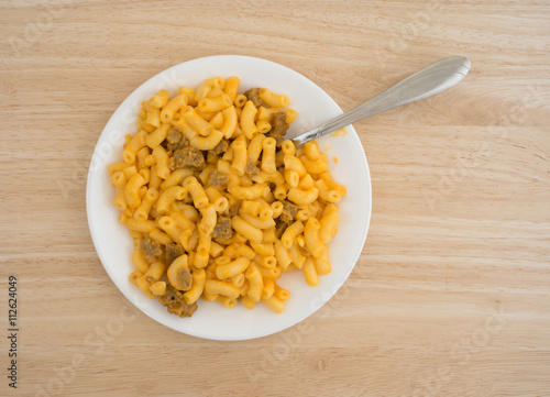 Mac and cheese with burger on plate with fork top view atop a wood table top