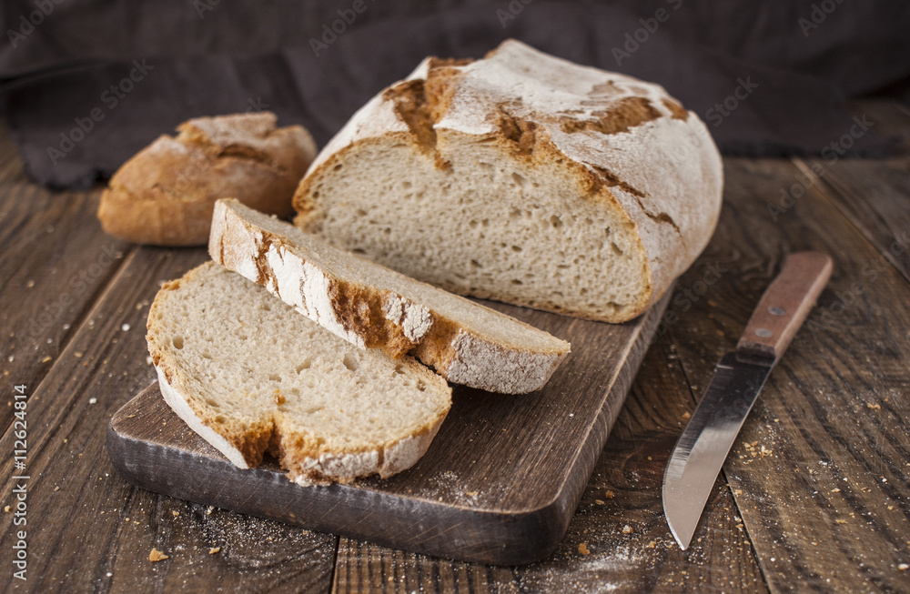 Sliced whole wheat bread and knife on rustic table, selective fo Sliced whole wheat bread and knife on rustic table, selective fo