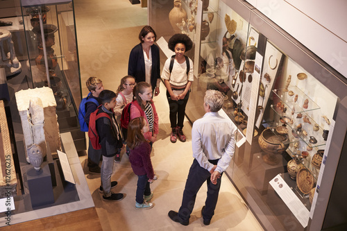 Students Looking At Artifacts In Case On Trip To Museum