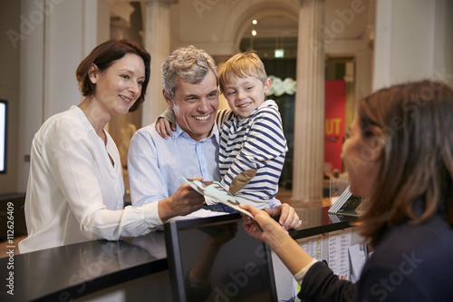 Family Buying Entry Tickets To Museum From Reception