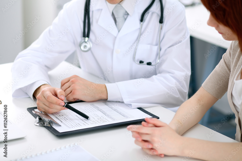 Doctor and patient are discussing something, just hands at the table Doctor and patient are discussing something, just hands at the table