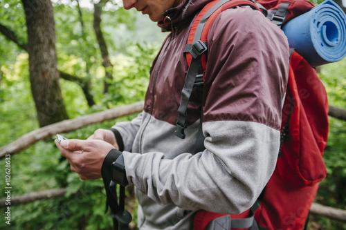 Serbia, Rakovac, young man using smartphone during hiking photo