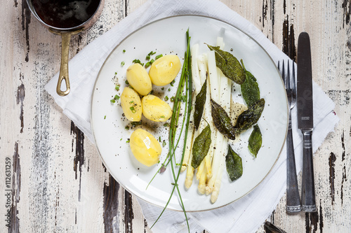 White asparagus with browned butter, fried sage leaves, boiled potatoes and chives photo