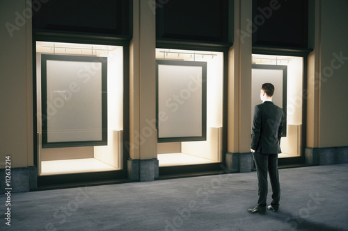 Showcase with frames and businessman