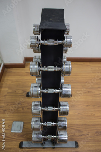 dumbbells set for weight training on rack in workout room photo