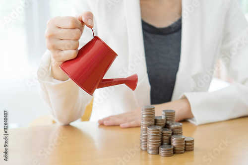 hand business woman and red watering can with money