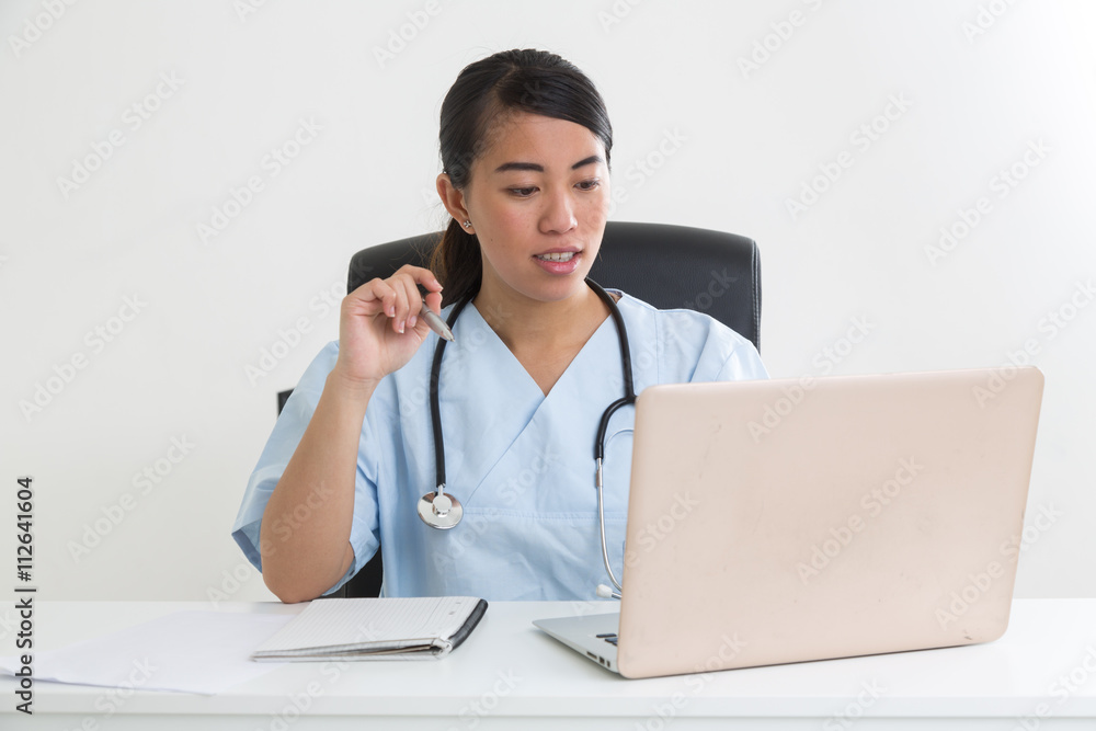 Helpful asian doctor at her desk Helpful asian doctor at her desk
