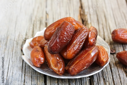 Dates fruit on wooden background, selective focus