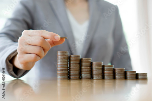 Billede på lærred Close-up Of A Businesswoman Making Stack Of Coins