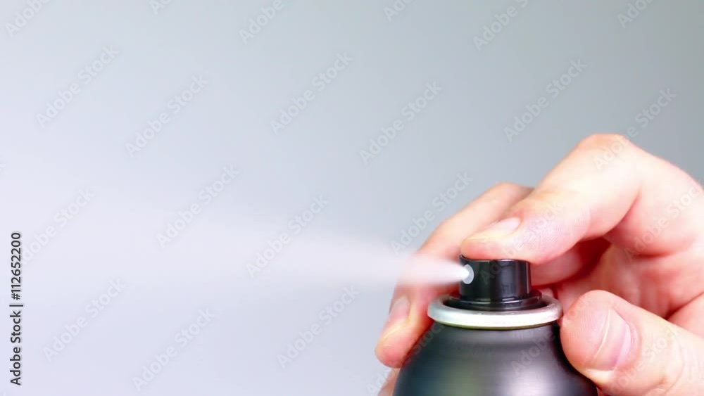 Finger pressing down three times on black aerosol can Finger pressing down three times on black aerosol can