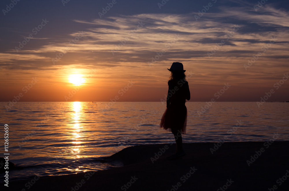silhouette of child in the beach at sunset