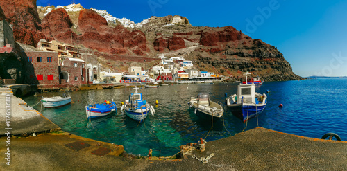 Panoramic view with fishing boats at Old port Amoudi of Oia village at Santorini island in Aegean sea, Greece