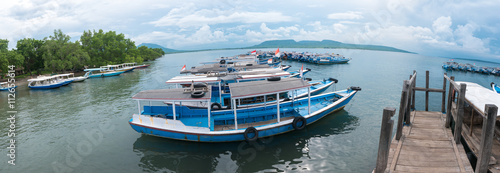 Wooden pier with Balinese boats near Taman Barrat National Park, photo