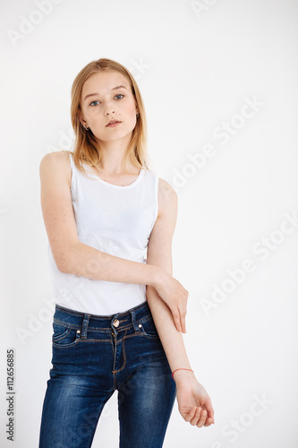 Young European woman posing in studio for test photo shoot showing different poses standing