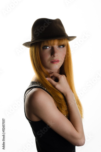 beautiful red-haired girl with a hat in the studio    © s72677466