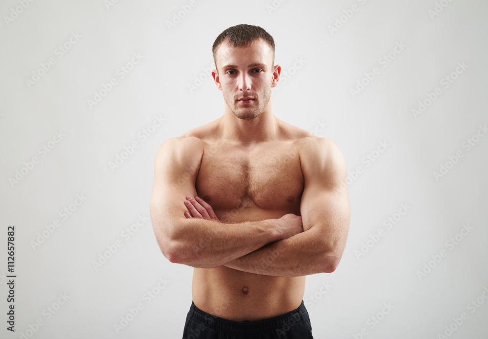 Fototapeta premium Bare-chested man is standing with crossed arms.
