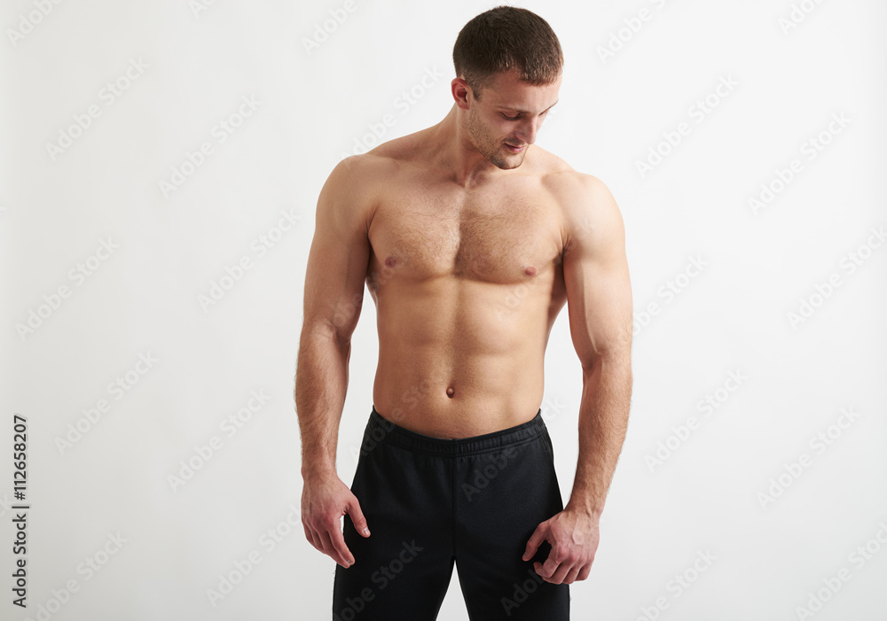 Muscular man over white background is looking down Muscular man over white background is looking down