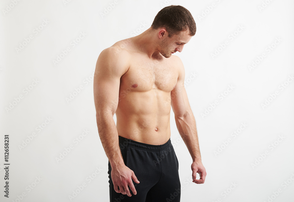 Muscular man over white background looking down at his hand Muscular man over white background looking down at his hand