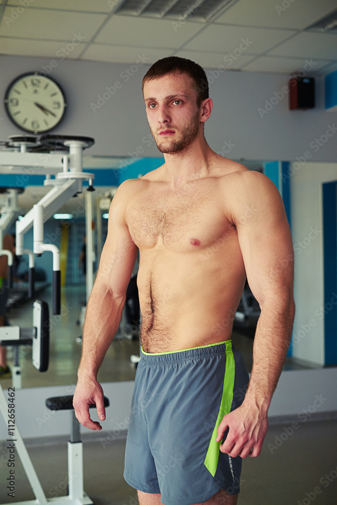 Obraz premium Young muscular man with bare chest in gym