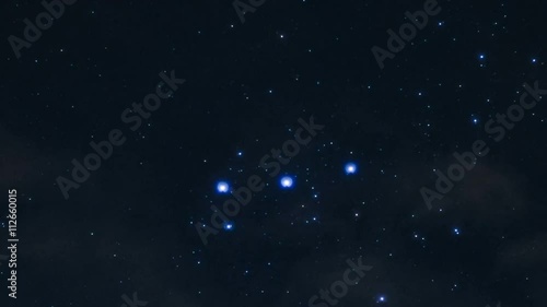 zooming time lapse of the stars of constellation Orion moving in the background of night clouds