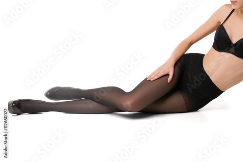 Slim woman in bra and tights on floor