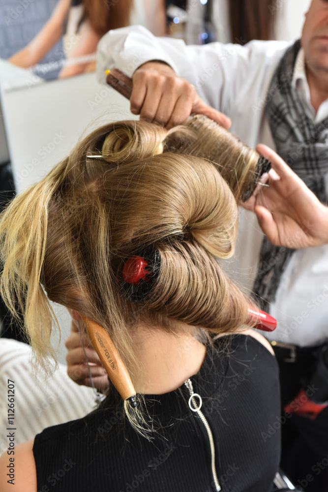 Hair curling process. Hairdresser woman curls her hair. Creating hairstyles hairdresser. Professional tool for creating curls Hair curling process. Hairdresser woman curls her hair. Creating hairstyles hairdresser. Professional tool for creating curls
