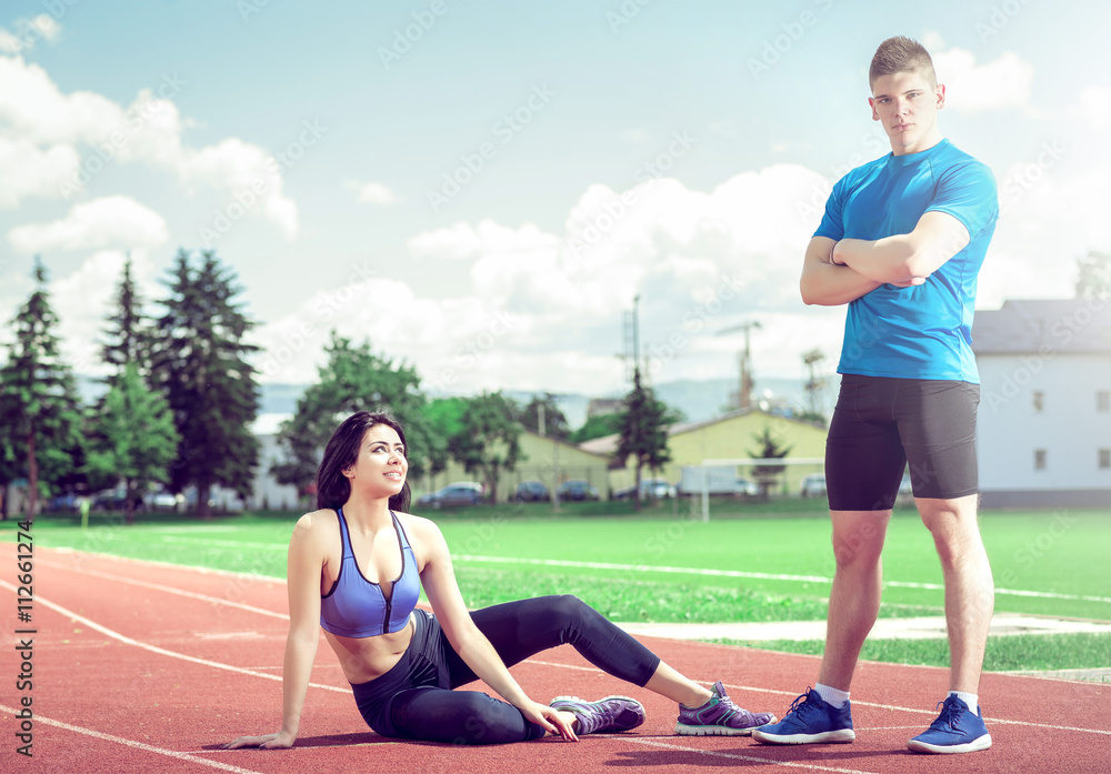Girl on track with her personal trainer.