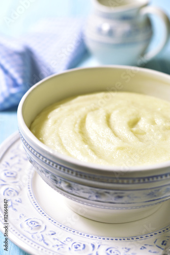 Semolina porridge in a vintage bowle on blue wooden table.