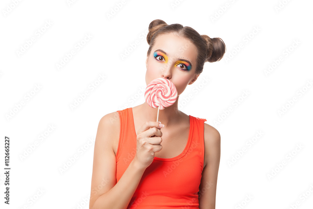 Brunette girl with buns biting lollipop Brunette girl with buns biting lollipop