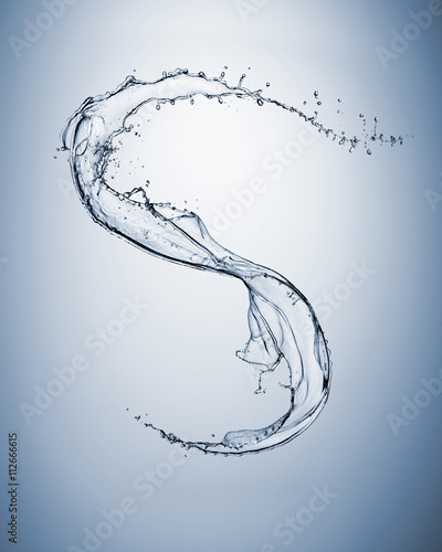 Close up of water splash shaping letter S on blue background photo