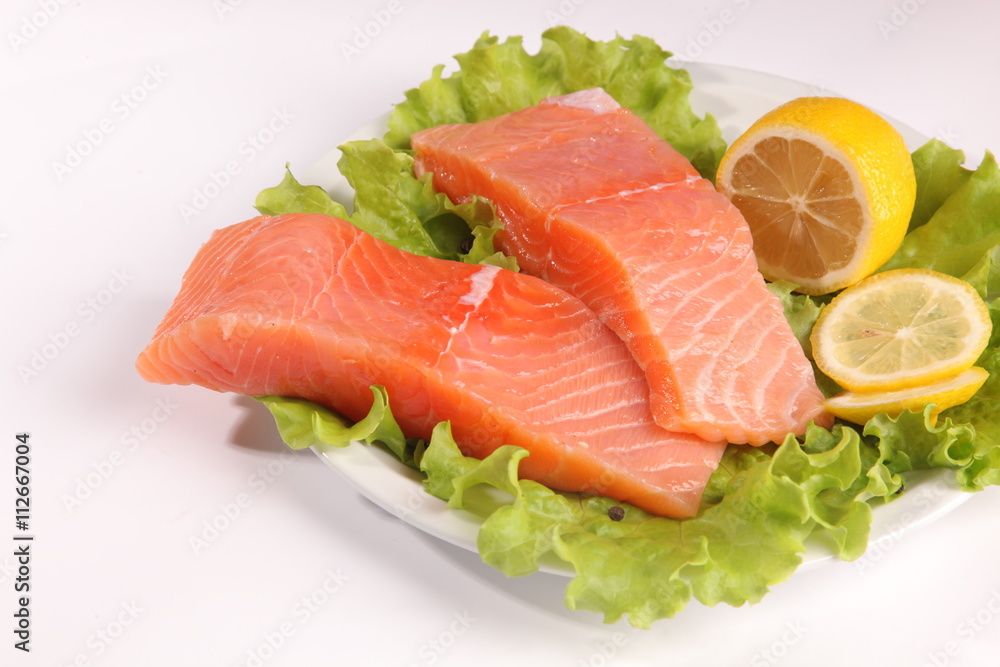 salmon on a plate with salad and lemon