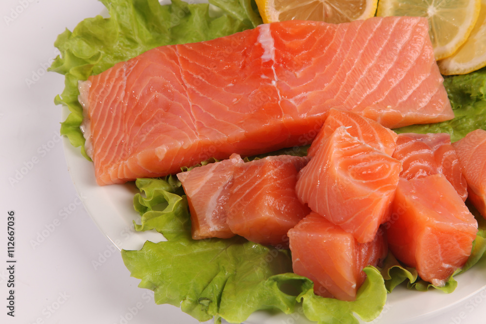 salmon on a plate with salad and lemon