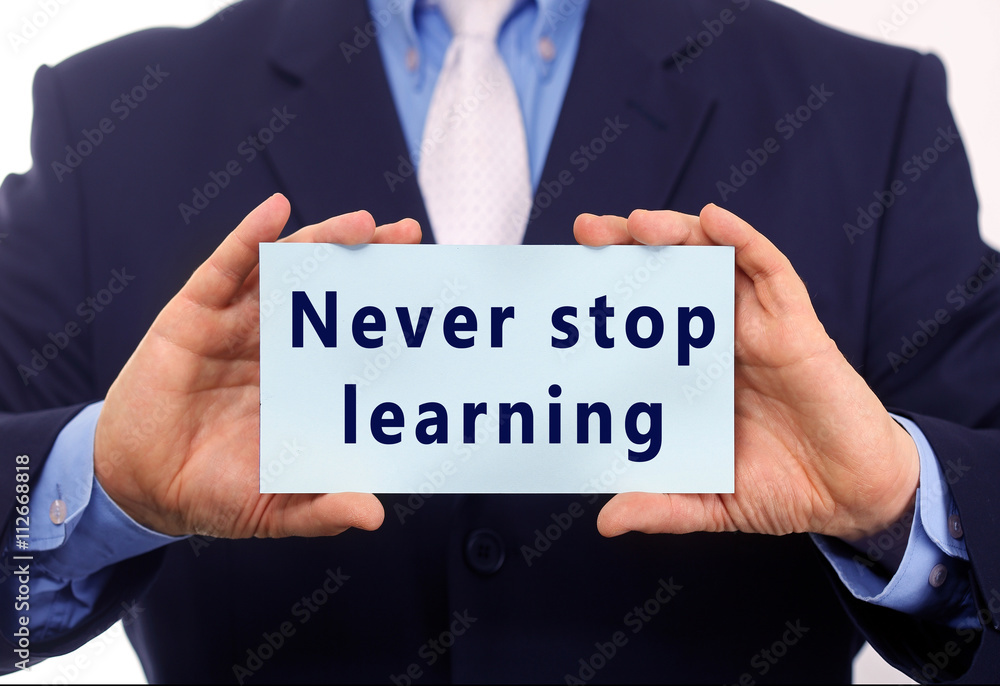 Business man hold paper never stop learning text on it Business man hold paper never stop learning text on it