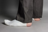 sideways standing feet with white socks and a big hole in front