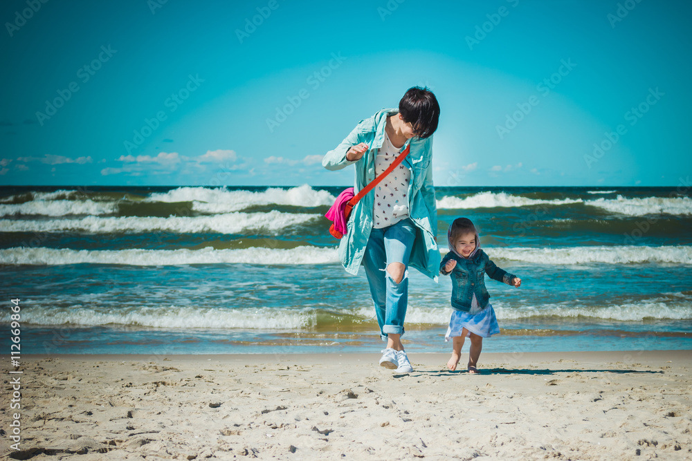 mother and daughter run on the beach mother and daughter run on the beach