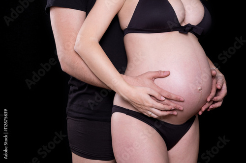 Man hands touching stomach of his pregnant woman
