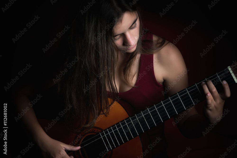 Obraz premium Beautiful teenage girl playing a guitar