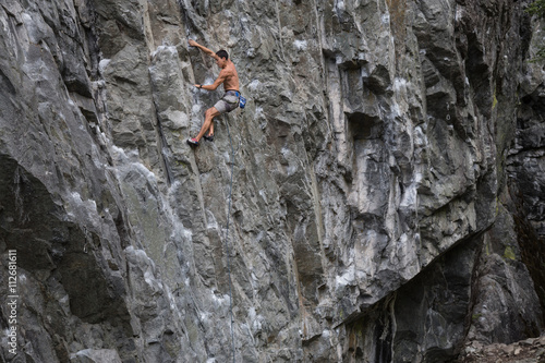 Rock Climber climbing a steep cliff on a mountain. Taken near Squamish, British Columbia, Canada