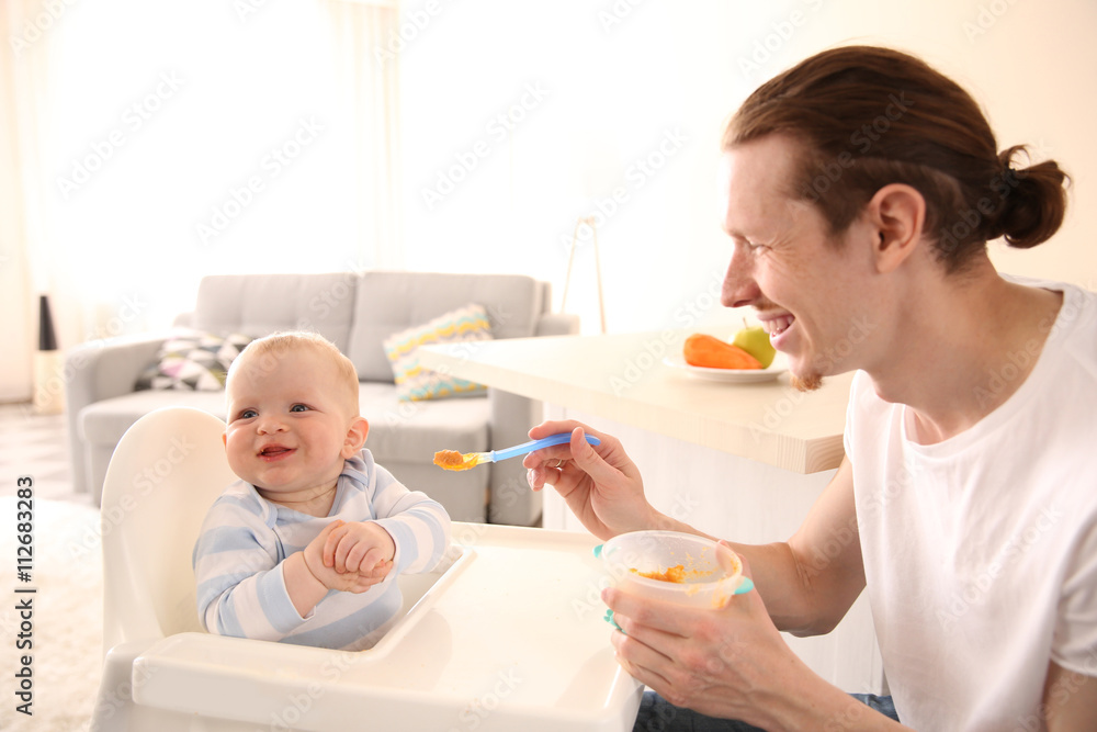 Father feeding his baby son Father feeding his baby son