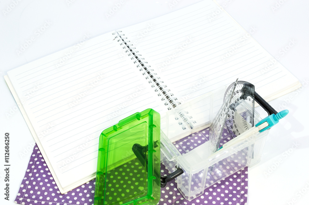 Obraz premium Empty white paper notebook with ruler, protractor, angle, triangle, square on the white background.