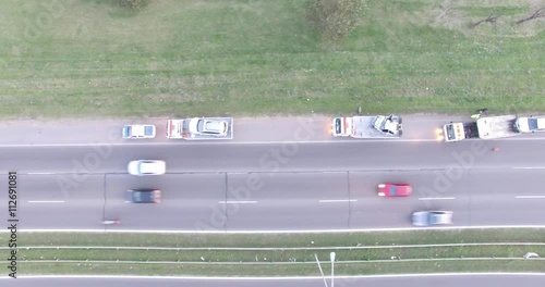 Aerial drone scene of higway. Car accident, police and smashed car at the side of the highway. Cars moving along. Top view.