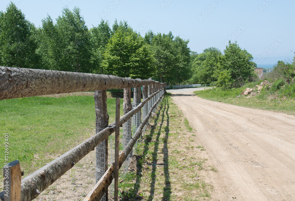 Rural cattle-pen with wooden fence along the road Rural cattle-pen with wooden fence along the road