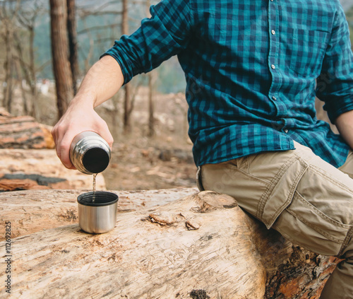 Man pouring tea in the forest