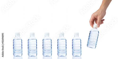 Male's hand grabs and holds a bottle of water with another bottl photo