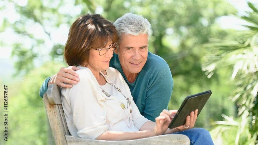 Senior couple using tablet in backyard Senior couple using tablet in backyard