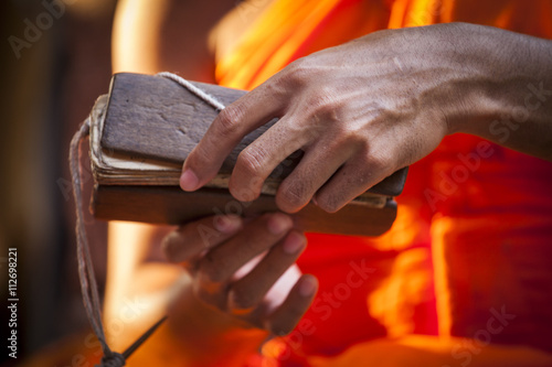 Asian monk with orange tunic read the future in Angkor Wat temple, Cambodia
