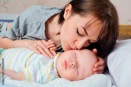 Portrait of beautiful mother with her 7 months old baby sleeping © Studio Romantic