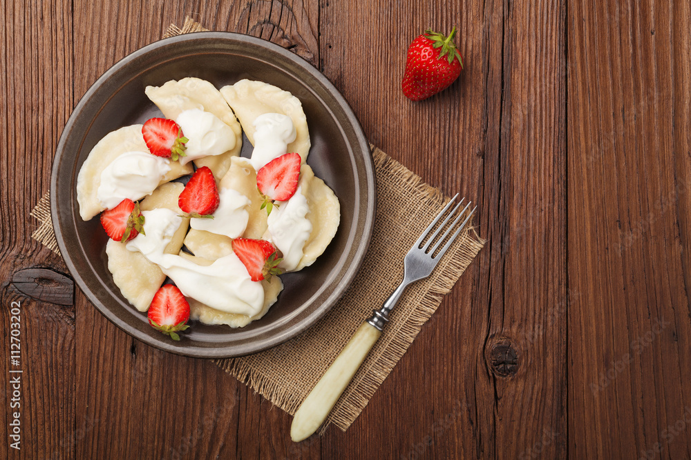 Delicious dumplings with fresh strawberries served with whipped