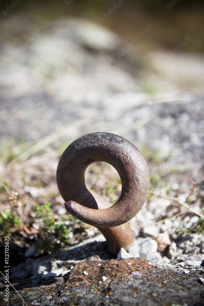 Rusted hook in a stone. Toned image with copy space Rusted hook in a stone. Toned image with copy space
